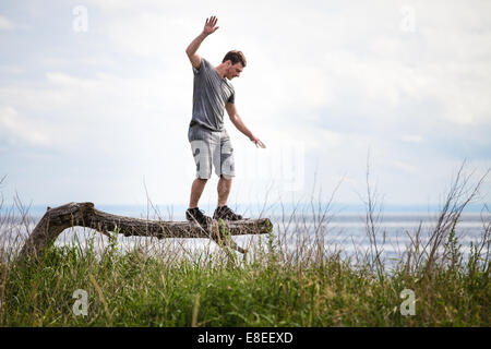 Young Adult balancieren auf einem toten Baum in der Natur in Urlaub, nur so zum Spaß Stockfoto