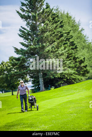 Reife Golfer auf einem Golfplatz zu Fuß mit Golf-bag Stockfoto