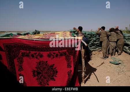 Kurdische Kämpfer der People's Defence Forces HPG dem militärischen Flügel der Kurdischen Arbeiterpartei PKK Scannen mit Fernglas ISIS oder ISIL-Position an einer Front Außenposten im Dorf Uzeira in der Nähe der Stadt Kirkuk im Nordirak Stockfoto