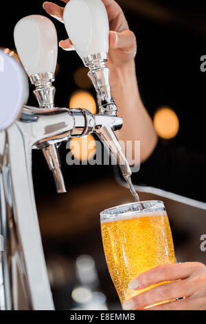 Gießen ein blondes Bier vom Fass in ein Bier direkt aus dem Wasserhahn Stockfoto