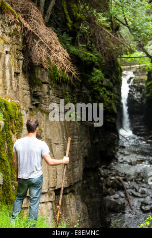 Wanderer, Blick auf den Wasserfall in der wilden Natur an einem regnerischen Tag Stockfoto