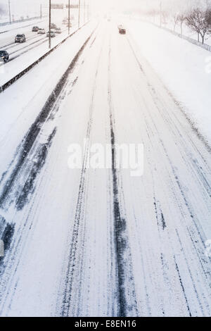 Störenden Sonnenuntergang Licht und Schneesturm auf der Autobahn aufgrund der schlechten Sichtbarkeit Stockfoto