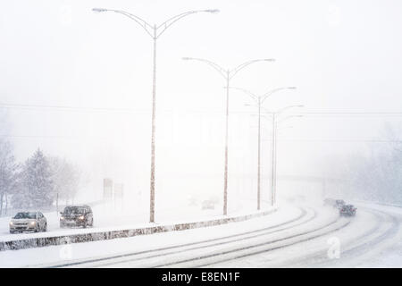 Störenden Sonnenuntergang Licht und Schneesturm auf der Autobahn aufgrund der schlechten Sichtbarkeit Stockfoto