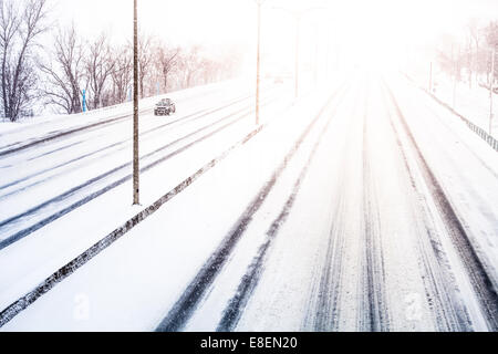 Störenden Sonnenuntergang Licht und Schneesturm auf der Autobahn aufgrund der schlechten Sichtbarkeit Stockfoto