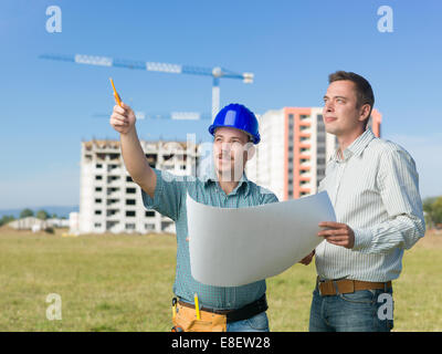 Architekt und Konstruktionsleiter Pläne vor Ort zu besprechen Stockfoto