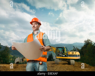 Vorderansicht des Ingenieurs auf Baustelle mit plan Stockfoto