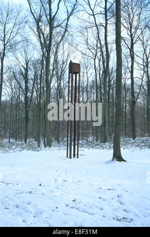 Moderne Skulptur der kleinen Hütte auf hohen Beinen im verschneiten Wald Stockfoto