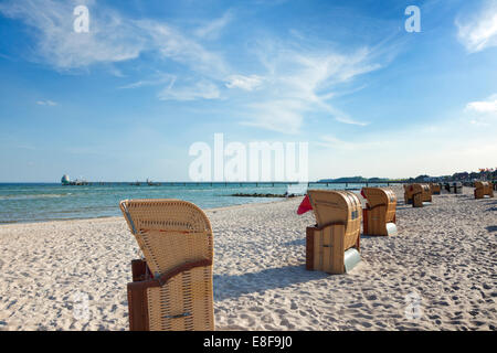 Strandkörbe am He Strand von Grömitz, Ostseeküste, Pier im Hintergrund Stockfoto