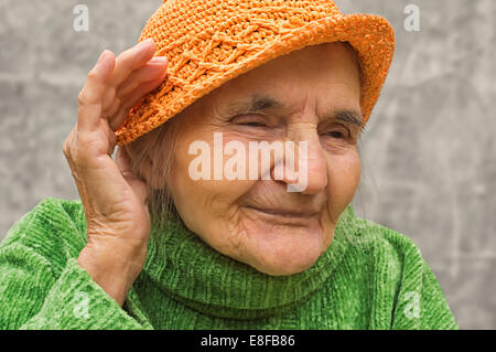 Ältere Frau mit Hand in der Nähe des Ohres. Hörprobleme. Stockfoto
