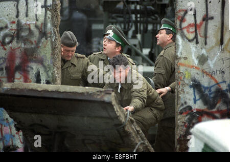 DDR-Grenztruppen Polizei schließen ein Loch Menschen ergab sich in der Berliner Mauer, 11. November 1989. Unter dem Druck des Volkes öffnete die DDR seine Grenzen am 9. November 1989. Nach 28 Jahren ist die Berliner Mauer kein sinnvoller. Stockfoto