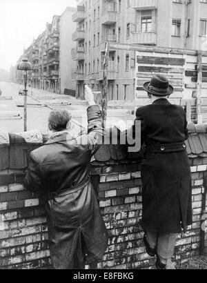 Zwei Männer aus West-Berlin bringen die letzte Möglichkeit zur Welle über Berliner Mauer an ihre Verwandten und Freunde am 27. Januar 1962, vor eine komplette Partition aufgebaut wird. Stockfoto