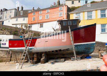 Traditionellen hölzernen Fischerboot repariert wird, während aus dem Wasser am Strand von Mevagissey Hafen, Cornwall, UK. Stockfoto