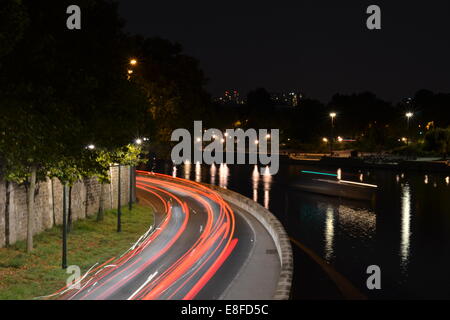 Folgen Sie dem Licht. Pris Sur le Pont de Île Saint Louis.  Verkehr bewegt durch Paris spät in der Nacht im Sommer. Stockfoto