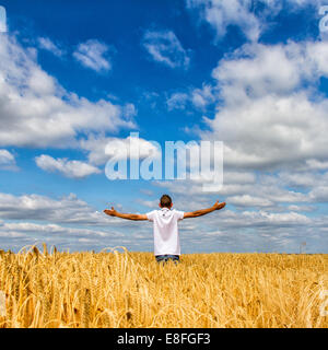 Rückansicht des Menschen stehen im Feld mit ausgestreckten Armen Stockfoto