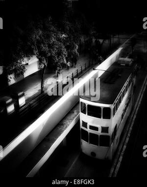 Straßenbahn fahren durch die Stadt bei Nacht, Hong Kong, China Stockfoto