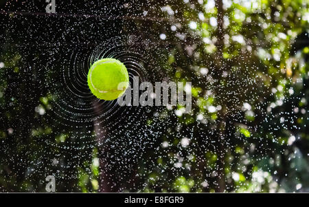 Nasser Tennisball, der durch die Luft fliegt Stockfoto