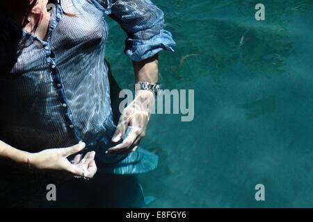 Voll bekleidete Frau in einem Schwimmbad Stockfoto