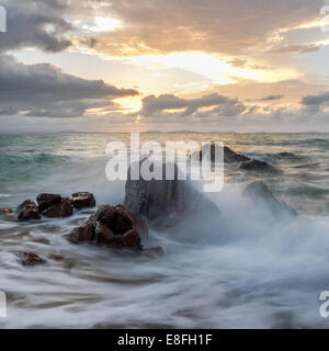 Wellen gegen Felsen Stockfoto