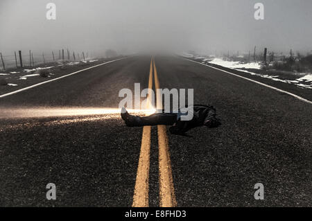 Mann mit Taschenlampe liegt mitten auf der Straße im Nebel, Idaho, USA Stockfoto