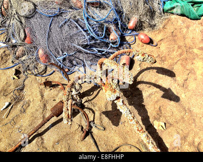 Oman, Maskat, Fischernetz und Anker am Strand Stockfoto