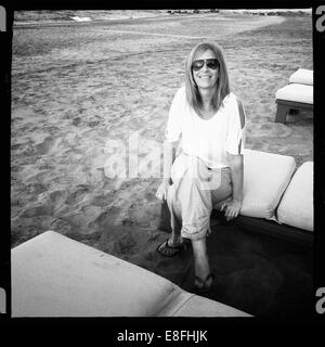 Lächelnde Frau auf einer Sonnenliege am Strand, Maskat, Oman Stockfoto