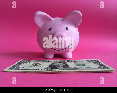 Sparschwein und Banknoten auf rosa Hintergrund Stockfoto
