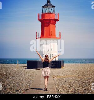 Frau stand vor Leuchtturm Stockfoto