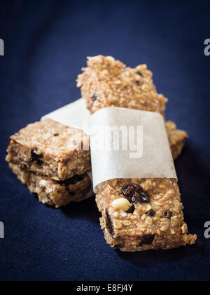 Hausgemachtem Müsli-Protein-Riegel mit Erdnussbutter, Honig, Nüssen, Kakao und Rosinen. Stockfoto