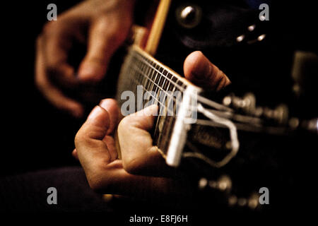 Nahaufnahme eines jungen Mannes, spielt akustische Gitarre Stockfoto