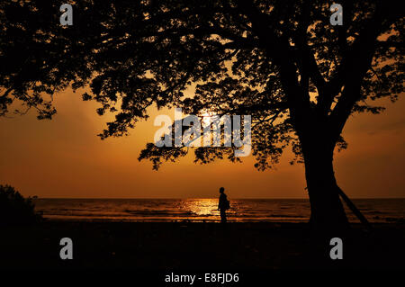 Indonesien, Süd-Kalimantan, Banjarmasin, Silhouette der Mann zu Fuß am Strand Stockfoto