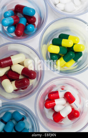 Ansicht von oben auf Glasschüsseln mit bunten Pillen gefüllt Stockfoto