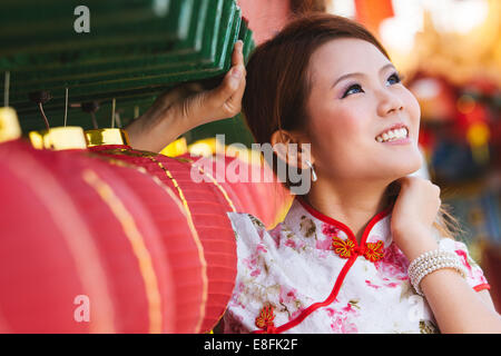 Porträt der jungen Frau, die durch chinesische Papierlaternen Stockfoto