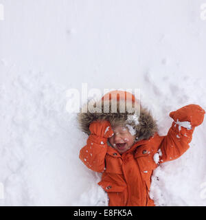 Glücklicher Junge im Schnee liegend, Lake Tahoe, Kalifornien, USA Stockfoto