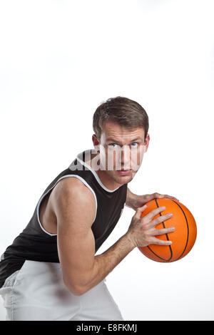 Porträt eines Basketballspielers, der einen Basketball hält Stockfoto