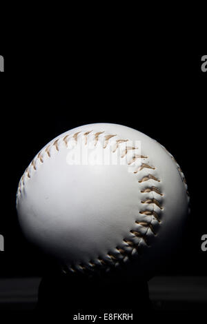 Nahaufnahme eines Baseballballs auf einem Tisch mit schwarzem Hintergrund Stockfoto