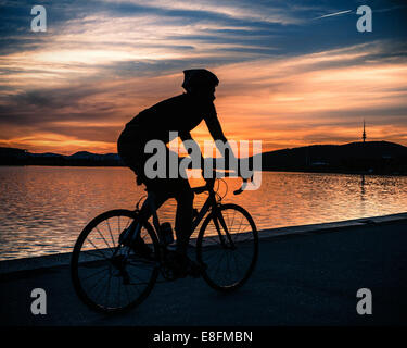 Silhouette der Radfahrer bei Sonnenuntergang in der Nähe von Lake Burley Griffin, Canberra, Australien Stockfoto