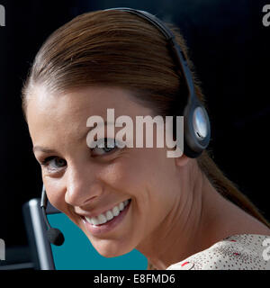 Porträt von lächelnden Geschäftsfrau trägt Kopfhörer Stockfoto