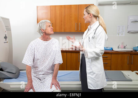 Ärztin im Gespräch mit männlichen Patienten neben MRI Scanner Stockfoto