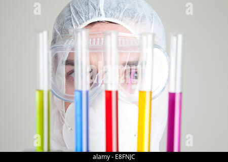 Wissenschaftler betrachten Reagenzgläser im rack Stockfoto