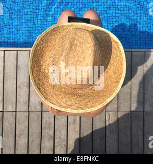 Draufsicht der Frau mit digital-Tablette sitzen am Rand des Swimming pool Stockfoto