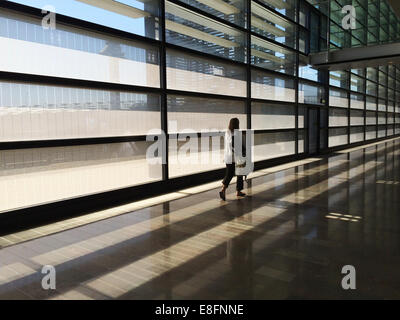 Frau zu Fuß durch leeren Flughafen Stockfoto