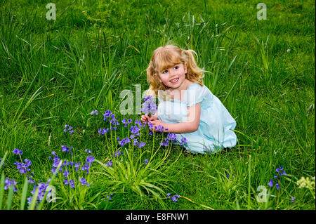 UK, Warwickshire, Rugby, glückliches Mädchen (4-5) Abholung Glockenblumen auf Wiese Stockfoto