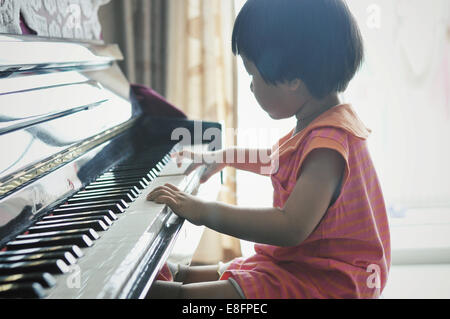 Junges Mädchen (2-3) Klavier zu spielen Stockfoto