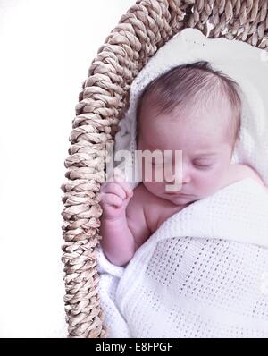 Babymädchen schlafen im Körbchen Stockfoto