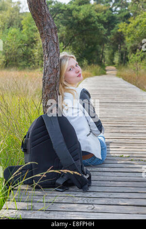 Mädchen sitzen auf hölzernen Pfad in der Natur Stockfoto