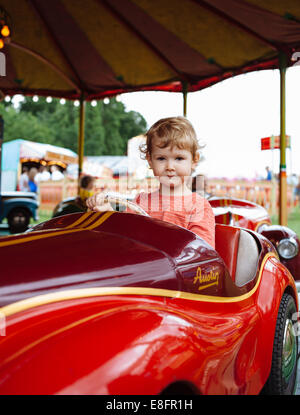 Junge auf Karussellfahrt auf Rummelplatz Stockfoto