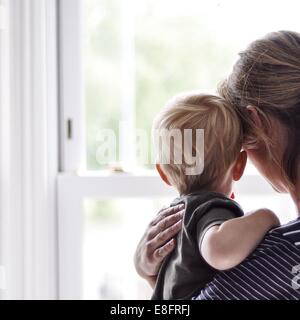 Mutter und Sohn aus dem Fenster Stockfoto