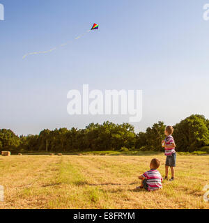 Zwei Jungen auf einem Feld fliegen einen Drachen, England, Großbritannien Stockfoto