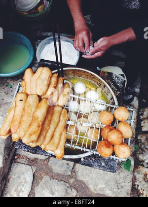 Vietnam, Lao Cai Provinz, Sa Pa, Frau Frittieren Teig auf der Straße Stockfoto