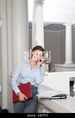 Porträt von Lehrerin im Universitätsgebäude mit Handy Stockfoto